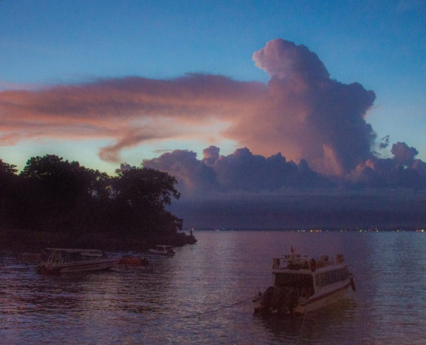 Vanaf Mushroom Beach heb je een mooi uitzicht op de (hier in wolken gehulde) bergen van Bali.