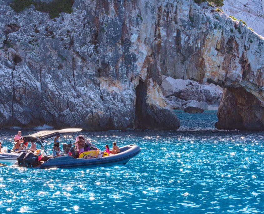 Boten varen af en aan. Cala Gonone is echt een tourist trap.
